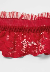 Liga de encaje rojo con bordes rizados y un patrón floral. Suave al tacto, banda elástica y detalles intrincados que realzan el diseño general.