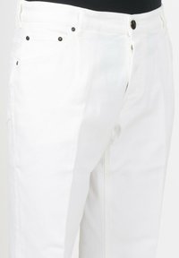 I pantaloni in denim bianco presentano un design a gamba dritta con tasche frontali visibili e accessori in metallo nero. Il tessuto è liscio con una minima texture.