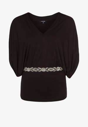 Zwarte top met een V-hals en losse vleermuismouwen, met een bewerkte riemaccent met een geometrisch patroon op de taille.