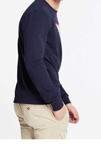 Sudadera de color azul marino con mangas largas, cuello redondo y puños acanalados. Presenta un diseño gráfico en la parte frontal y está hecha de una tela suave.