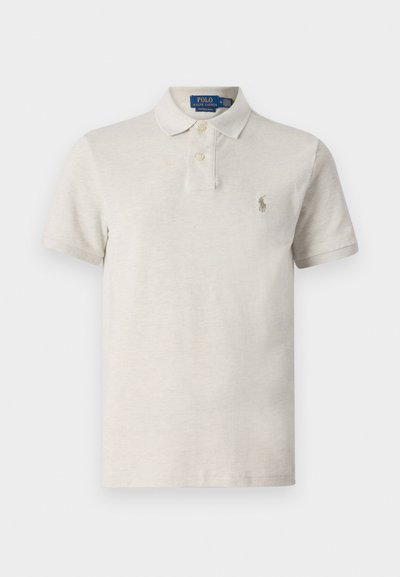 Μπέζ πόλο πουκάμισο με δύο κουμπιά στον γιακά, κοντά μανίκια και ένα μικρό κο embroidered logo στο αριστερό στήθος. Μαλακή υφή, χαλαρός σχεδιασμός.