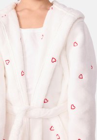 Biely fleece župan s kapucňou, s vyšívaným červeným srdcom. Navrhnutý s opaskom a mäkkou textúrou, ktorý zdôrazňuje pohodlie a teplo.
