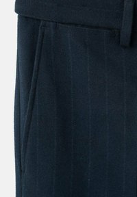 Granatowe, dopasowane spodnie z pionowym wzorem w prążki, z płaskim przodem i kieszeniami po bokach, wykonane z tkaniny z mieszanki wełny o delikatnej fakturze.