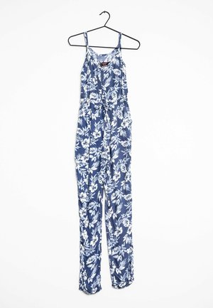 Blauwe mouwloze jumpsuit met witte bloemenprint, hangend aan een zwarte hanger tegen een witte achtergrond.