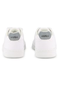 Λευκά αθλητικά παπούτσια με λείο δερμάτινο εξωτερικό, επενδεδυμένο κολάρο και γκρι λεπτομέρειες στη φτέρνα με το λογότυπο "HUGO". Υφή στην σόλα.