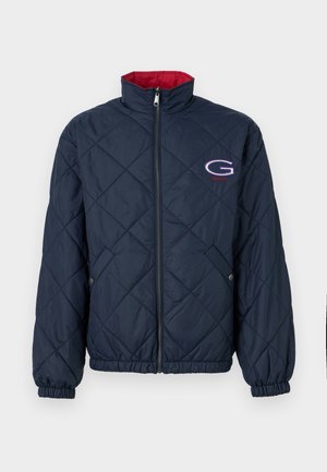 Marineblå quiltet jakke med rød indvendig krave, frontlynlås, elastiske manchetter, sidelommer med knapper og et "G"-logo på brystet.