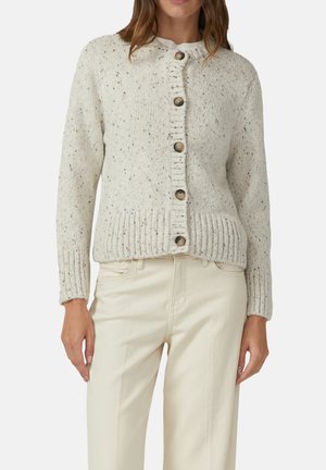 Cardigan lavorato a maglia di colore crema con scollatura tonda, chiusura frontale con bottoni e polsini e orlo a coste. Presenta una texture maculata e bottoni in legno.