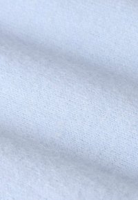 Tissu tricoté bleu clair et doux avec des fibres fines et duveteuses, avec une surface subtilement texturée en doux plis.