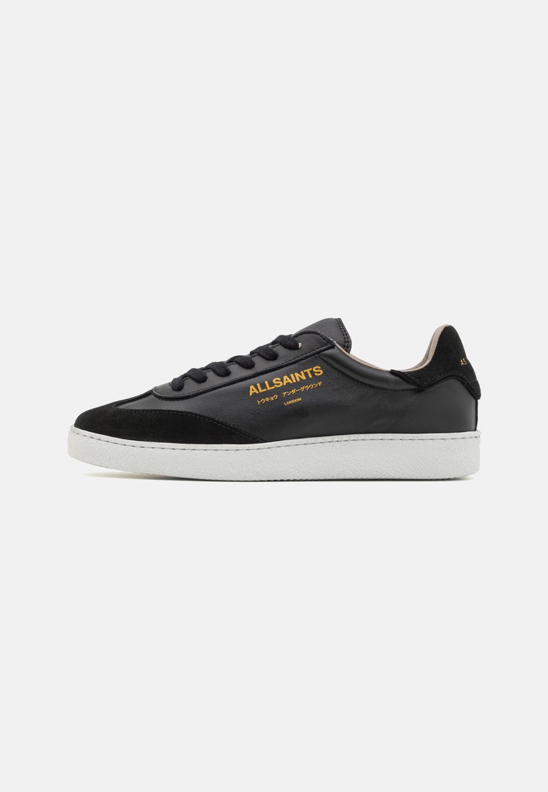 Sneakers in pelle nera con dettagli in suede, suola in gomma bianca, lacci neri e logo dorato laterale. Design low-top.