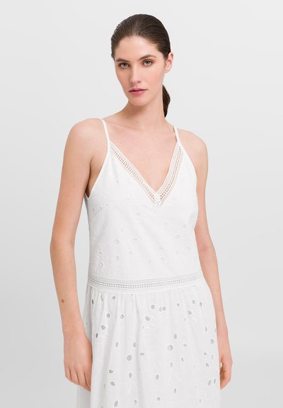 Rochie albă cu decolteu în V, având dantelă pe margini, broderie delicată și decupaje circulare. Bretele ajustabile tip spaghetti și fustă fluidă.