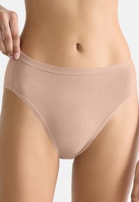 Mutandine beige a vita alta in un tessuto liscio ed elasticizzato con un design senza cuciture. Presentano una fascia morbida in vita e senza cuciture visibili.