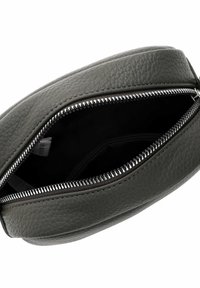 Szara skórzana saszetka o teksturowanej powierzchni, wyposażona w srebrny suwak i o okrągłym kształcie, otwarta, ukazująca wnętrze.