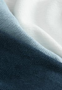 Három színű szövetek: sötét tengerészkék, világoskék és fehér. A texturált felületek szövött mintát mutatnak, változó vastagságokkal.