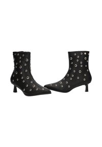 Botines negros de tobillo con punta afilada, de cuero texturizado, decorados con ojales de metal plateado y un tacón de gato. Acabado suave, diseño moderno.
