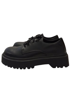 Le scarpe in pelle nera presentano una suola spessa e testurizzata, punta rotonda e un design con lacci, con un branding minimo sul lato.
