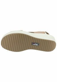 Sandalo platform beige con suola in gomma testurizzata, dotato di una soletta imbottita e cinturini larghi per supporto. Accento della zeppa bianco.