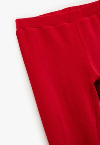 Rote Leggings aus weichem Stoff mit glatter Textur. Verfügt über einen elastischen Bund und ein eng anliegendes Design.