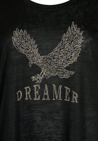 Černé tričko s volným střihem, s texturovaným designem orla a slovem "DREAMER" pod ním, osázeným kamínky.