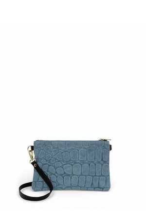 Pochette bracelet bleue en cuir synthétique imitation crocodile avec fermeture éclair dorée et bandoulière noire amovible sur fond blanc.