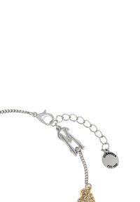 Zilveren armband met een gestructureerde ketting, voorzien van een goudkleurige klaver hanger versierd met rhinestones en een merklabel.