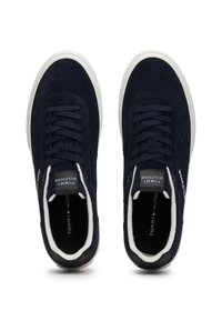 Zapatillas de ante azul marino con suelas de goma blanca, parte frontal con cordones, puntera redondeada, forro suave y marca en el lateral y la lengüeta.