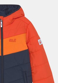 Giacca imbottita in arancione, giallo e blu navy. Presenta una chiusura con zip, cappuccio, bloccaggio dei colori orizzontale e un'etichetta brandizzata sulla manica.