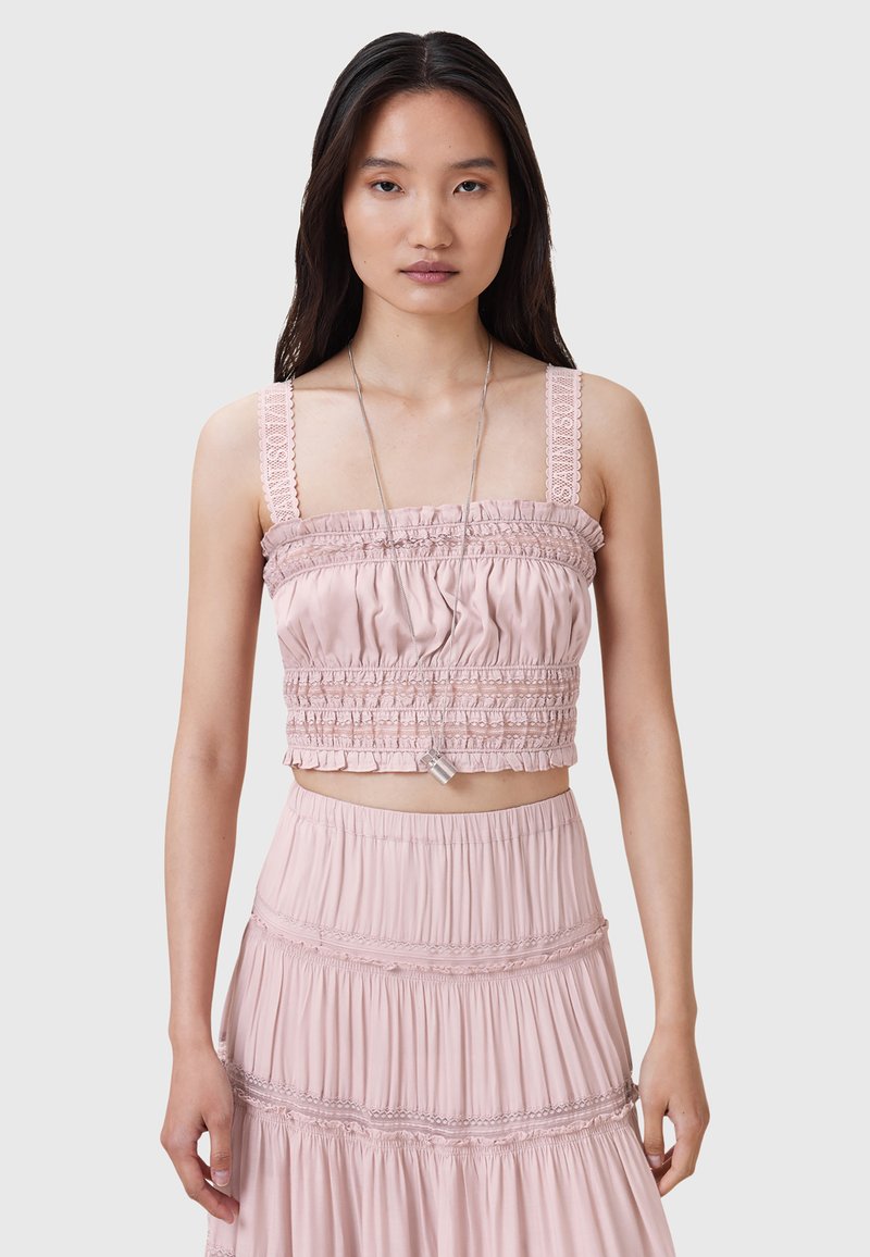 Lys pink cropped top med rynket tekstur og blondedetaljer på stropperne, parret med en matchende lagdelt nederdel med elastisk talje.