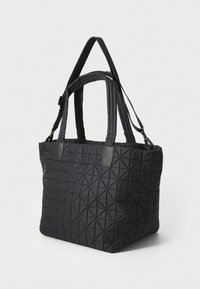 Czarna torba typu tote, pikowana, z trójkątnym wzorem, posiadająca dwa uchwyty i odpinany pasek, wykonana z trwałego materiału o gładkiej fakturze.