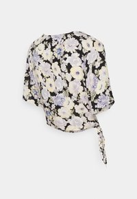 Blommig omslagstopp med svart bakgrund och gula, vita och blå blommor. Den har korta ärmar och en knytdetalj bak.