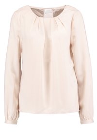 Blusa beige chiaro con maniche lunghe, scollo rotondo e tessuto morbido e liscio. Presenta pliche sul davanti e polsini arricciati.