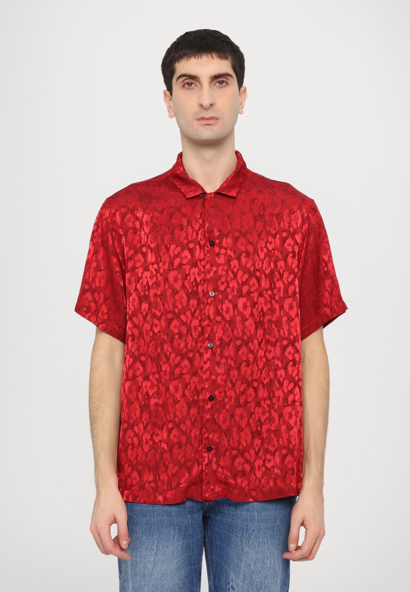 Rode kortemouwen shirt met een luipaardprint, gemaakt van een glanzend materiaal, met een knoopsluiting aan de voorkant en een klassieke kraag.
