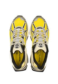 Scarpe sportive gialle e grigie con tomaia in rete, accenti neri e design a fantasia. Presentano lacci e logo sulla linguetta.