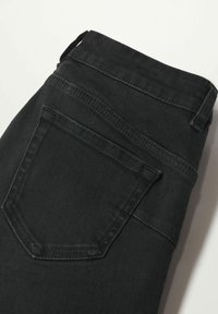 Pantalones vaqueros de mezclilla negra, con una cintura alta, bolsillo trasero y una textura limpia y suave. La tela tiene un ligero estiramiento para mayor comodidad.