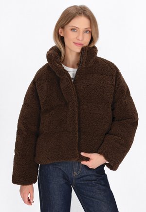 Bruine, donzige, oversized jas met een hoge kraag en een ritssluiting aan de voorkant. Geverfd materiaal en brede, omgeslagen mouwen.