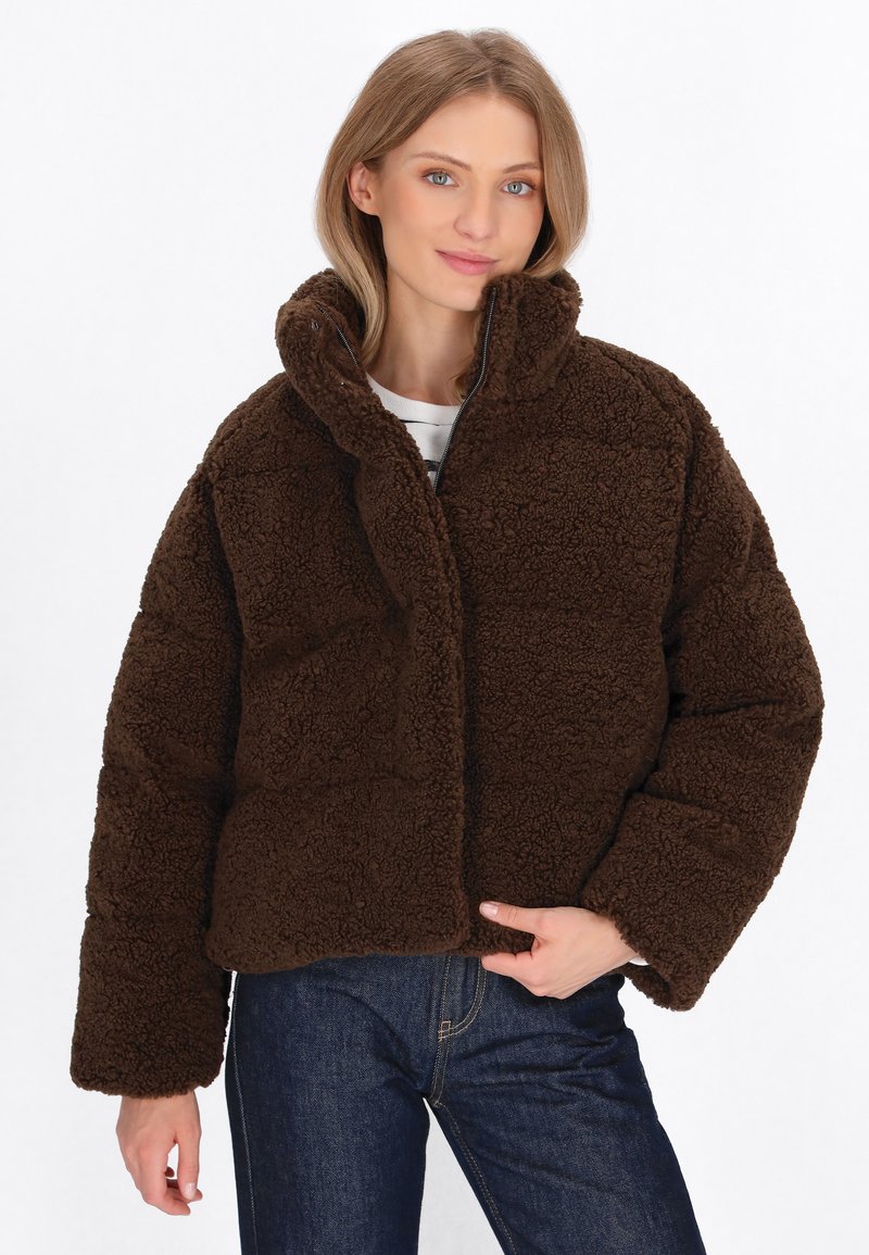 Braune, kuschelige, übergroße Jacke mit hohem Kragen und Reißverschluss vorne. Strukturierter Stoff und weite, umgeschlagene Ärmel.