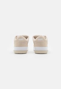 Beez suede tossud valgete kummitaldadega, millel on pehmendatud krae ja kontsapadi, ning mille tagaküljel on valge "VANS" bränd.