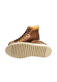 Stivaletti alla caviglia in pelle marrone con una texture intrecciata, dettagli in marrone chiaro e interno color nocciola. La suola è scanalata e di colore bianco sporco.
