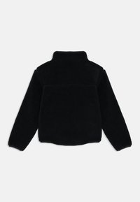 Chaqueta de forro polar negra con mangas largas y cuello alto, mostrada desde la espalda sobre un fondo blanco liso.