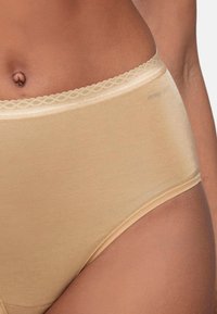 Beige korkeavyötäröiset alusvaatteet, jotka on valmistettu sileästä, joustavasta kankaasta. Niissä on herkkä pitsireunus vyötäröllä ja saumaton muotoilu.