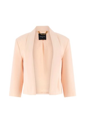 Hell pfirsichfarbener kurz geschnittener Blazer mit Schalkragen und dreiviertel Ärmeln, mit einem schwarzen Etikett und einer goldenen Kette im Nacken.