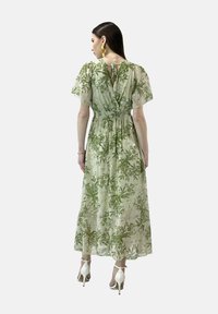 Helles grünes Maxikleid mit floralen Motiven, kurzen, fließenden Ärmeln und elastischem Bund. Verfügt über eine Schleife am Rücken und eine entspannte Silhouette.