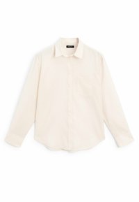 Lys beige langærmet skjorte lavet af blødt stof, med knaplukning foran, en enkelt brystlomme og en rundet kant.