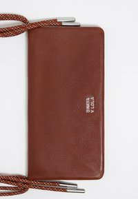 Portafoglio in pelle marrone con texture, dotato di cinghie in corda intrecciata, caratterizzato da dettagli metallici e un nome di marca impresso in argento.