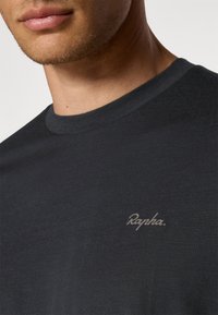 Tricou negru din bumbac cu guler rotund, având un logo subtil de culoare gri Rapha pe pieptul stâng, cu o textură netedă și un design ajustat.