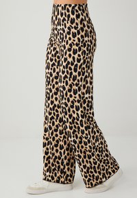 Leopardenprint wijde broek in zachte stof, met een beige achtergrond en zwarte vlekken, gedetailleerd met een hoge taille en uitlopende pijpen.