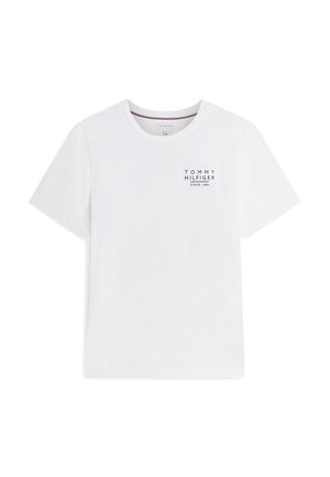 Camiseta blanca de manga corta con cuello redondo y pequeño texto "Tommy Hilfiger Since 1985" impreso en el pecho izquierdo.