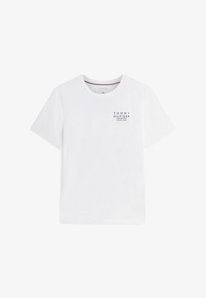 Camiseta blanca de manga corta con cuello redondo y pequeño texto "Tommy Hilfiger Since 1985" impreso en el pecho izquierdo.