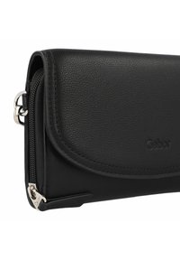 Cartera de cuero negra con acabado texturizado, un compartimento con cremallera y una solapa curva con el logo "Gabor" en relieve.