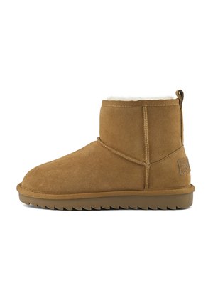 Bottines en daim marron avec semelle épaisse, coutures visibles, tirette au talon et doublure en fausse fourrure blanche à l'intérieur.