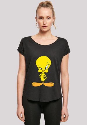 Svart t-shirt med en karaktärsdesign av en gul fågel. T-shirten har en rundad halsringning och korta upprullade ärmar, med en avslappnad passform.